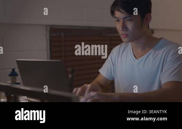 Young man working late on laptop computer Stock Video Footage - Alamy