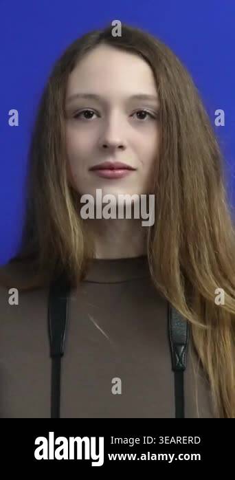 Young female photographer with long hair lifts her digital camera ...