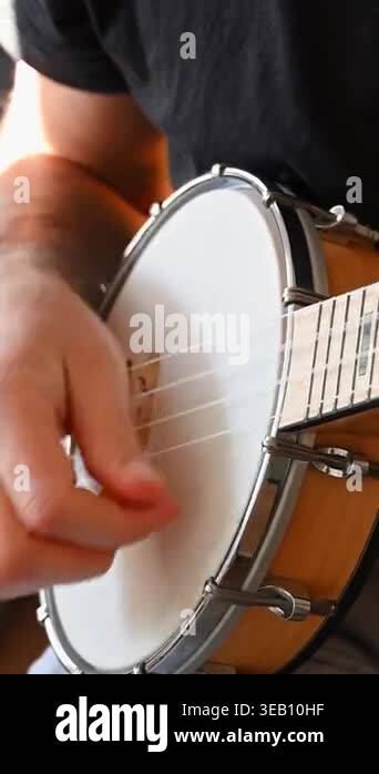 Circular String Instrument A detailed shot captures a person's hand rhythmically strumming the ...