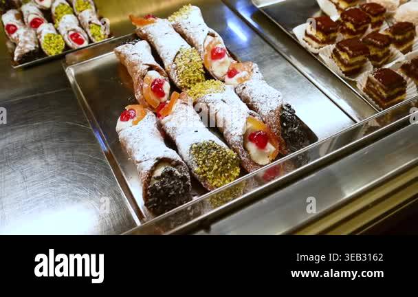 Fresh sicilian cannoli on a metal tray in a pastry shop display case ...