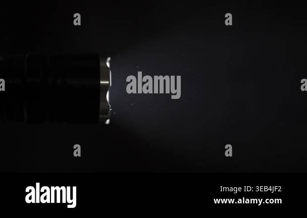 Flashlight Particles Tactical flashlight beam illuminates floating dust particles in a dark ...