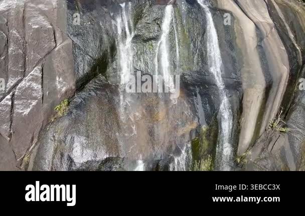 White Cliffs Water Rushing A powerful waterfall cascades from a towering mountain height, sending ...