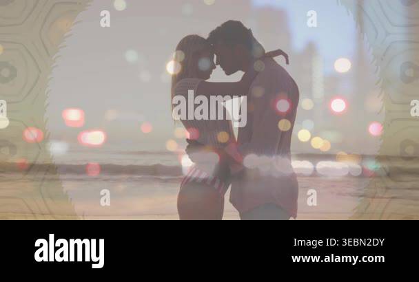 Woman placing arms around man, couple touching foreheads, bokeh skyline ...