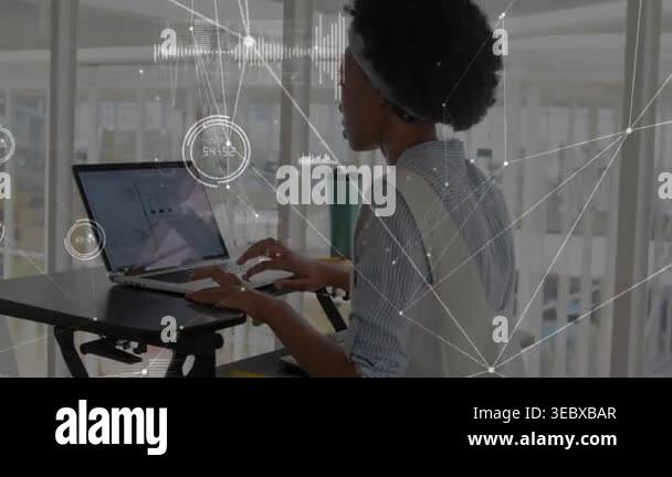 Woman typing and tapping laptop at standing desk in business ...