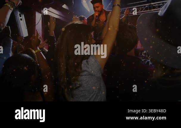 Center woman raising hands as concert singer singing into mic, confetti ...