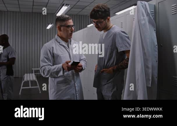 Two Focused Male Surgeons Use Smartphone App Review and Discuss Digital ...