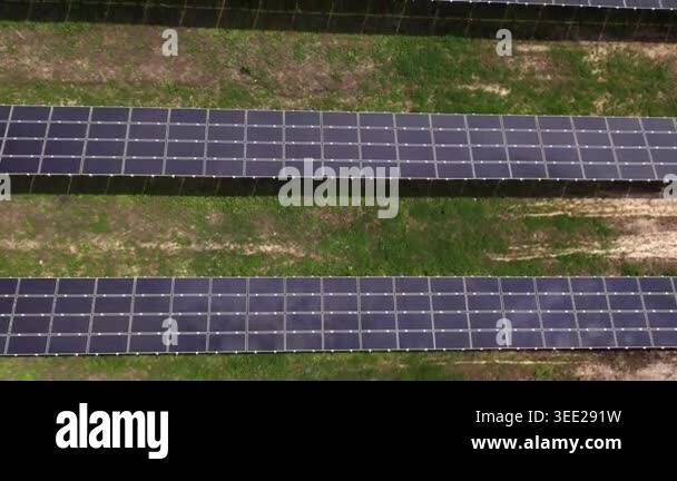 Aerial view of a solar farm with long rows of photovoltaic panels ...