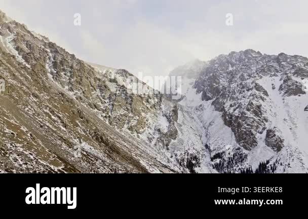 Majestic snow-capped mountains rise dramatically against a clear blue ...