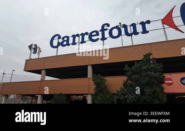 Exterior of a Carrefour supermarket with large rooftop logo signage on ...