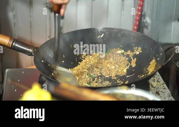 The process of cooking street food fried rice uses a hot pan over high ...