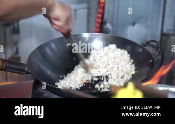 The process of cooking street food fried rice uses a hot pan over high ...