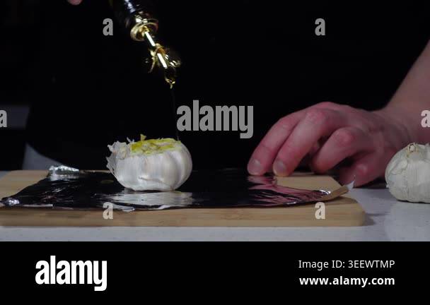 Drizzling oil on garlic and wrapping in foil for roasting Stock Video ...