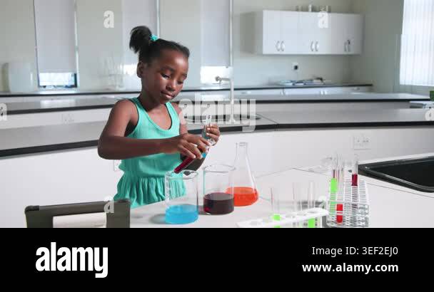 Teen female raising test tubes comparing colors pouring pipetting at ...