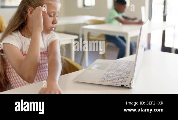 Youth female student reaching, hesitating, typing on laptop in ...