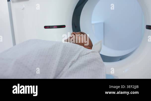 Stand Up Scanner Scanner is initiating scan, table is sliding patient into gantry while ...