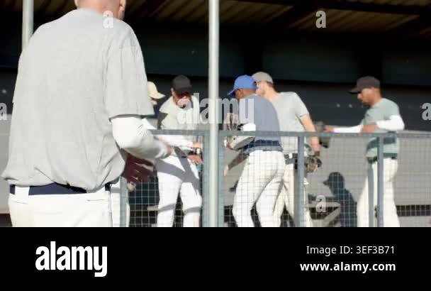 Jogging senior coach and players greeting at fence, leading huddle ...