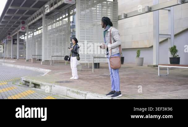 Bus Top Pull In Diverse commuters standing by bus stop, pulling phones placing helmet ...