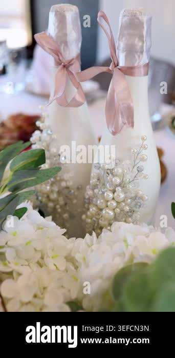 Two white champagne bottles decorated with pearls and blush ribbons ...
