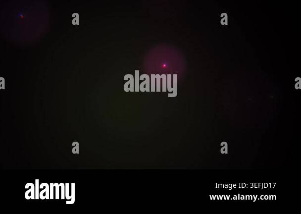 A dark abstract background featuring subtle glowing light spots and ...