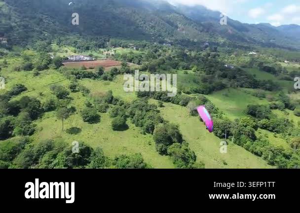 Aerial view of paraglider landing in a green mountain valley Stock ...