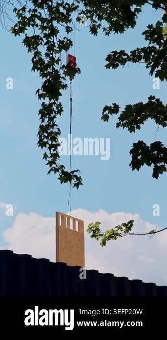 Hoisting mechanism delivering wood panel to building structure. Fast ...
