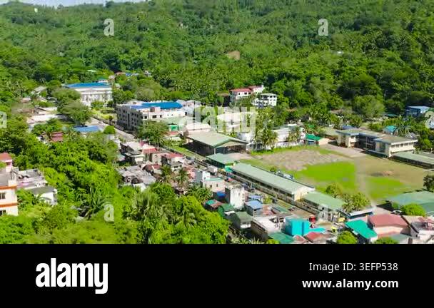 Aerial view of houses and buildings surrounded by mountain forest ...