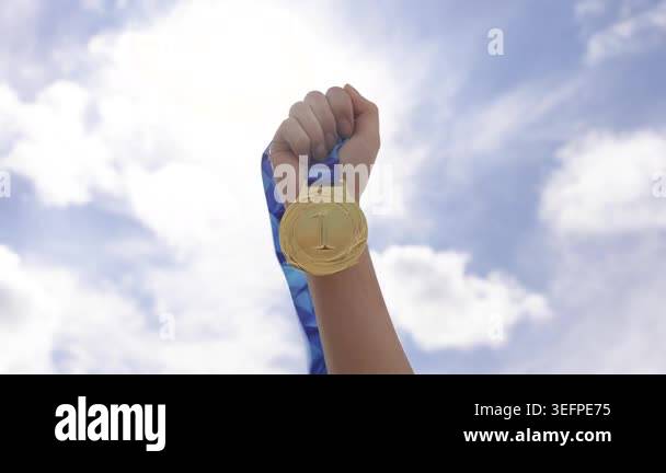 Gold Medal Held Against Sun Flare, Bright Rays Streaming Around Raised ...