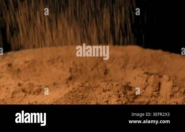 Cinematic sprinkle of raw cocoa powder on black background slow motion ...