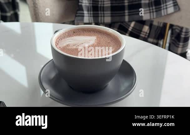 Close up of a cup of hot chocolate on a wooden tray at a terrace. High ...