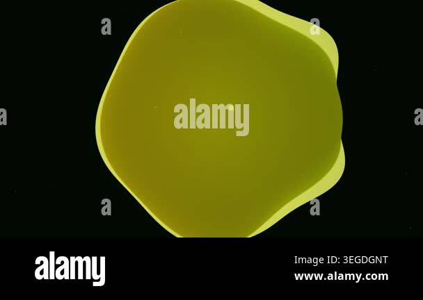Abstract yellow-green liquid blob morphing and pulsating on a black ...