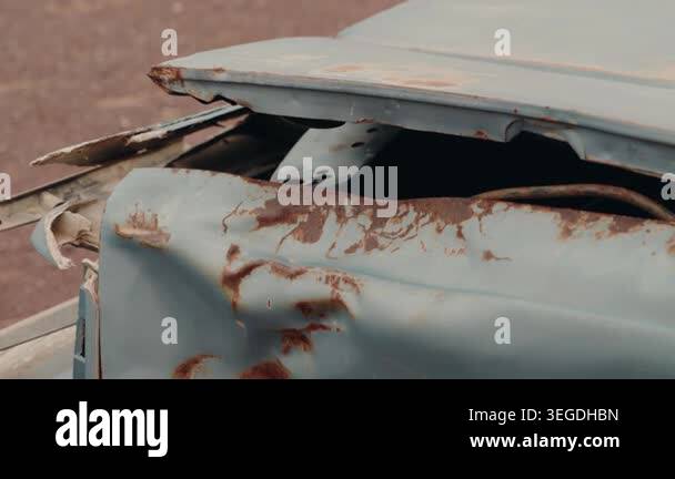 Rusty abandoned car in a deserted area. Damaged vehicle left to decay ...