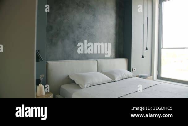 Modern bedroom interior with a large window, textured dark gray walls ...