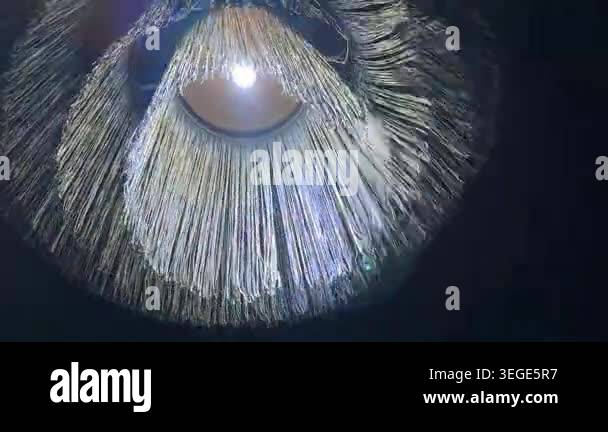 Modern chandelier swaying and creating mesmerizing light patterns in ...