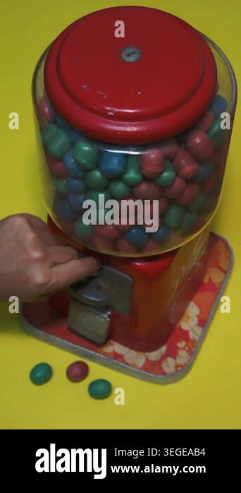 A retro gumball machine with colorful candy on yellow background ready ...