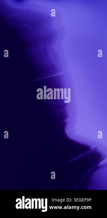 Vertical video. Ink drip. Color fluid. Defocused purple blue neon water ...