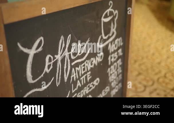 A chalkboard shows different types of coffee drinks with prices Stock ...