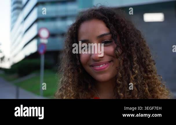 Young black woman looking at the camera with curly hair smiling ...