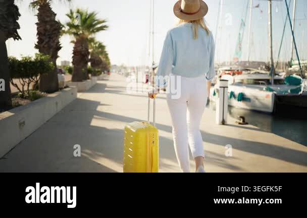 Young woman traveler wearing casual clothes, hold yellow suitcase while ...