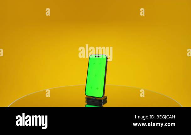 Modern smartphone standing on a reflective surface with green screen ...