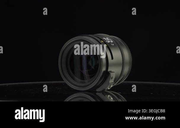Professional 55mm T1.4 cine lens displayed on a dark reflective surface ...