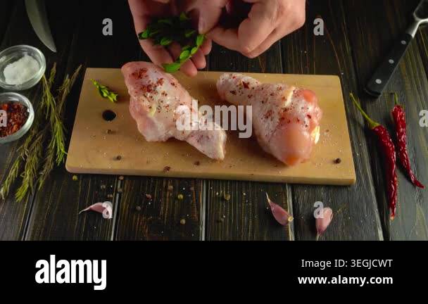 Hands of a person carefully sprinkle fresh herbs over two seasoned ...