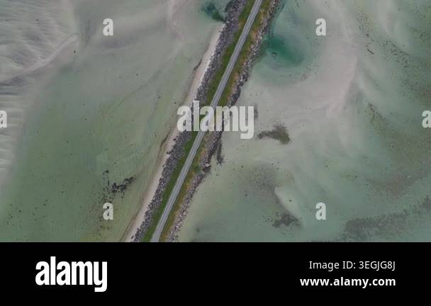 Aerial drone top down footage of narrow causeway road cutting through ...