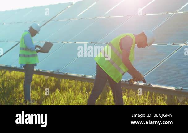 solar panels field inspection at sunrise, field technician performs ...
