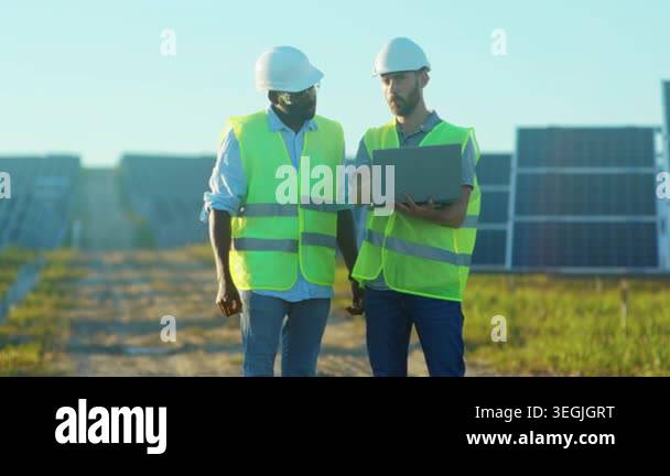 solar panel site walk and consultation, two engineers stroll between ...