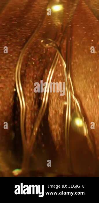 Vertical video. Glitter garland. Golden light. Defocused yellow orange ...