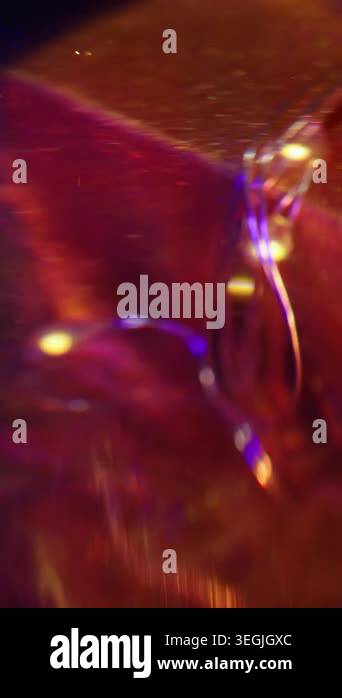 Vertical video. Ink spill. Luminous light. Defocused golden pink neon ...