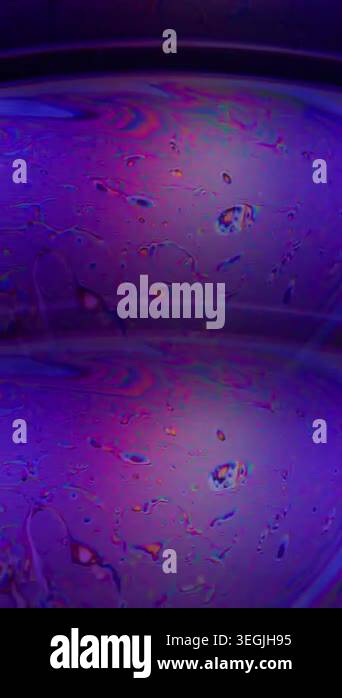 Vertical video. Defocused petroleum stain. Wet abstraction. Pink blue ...