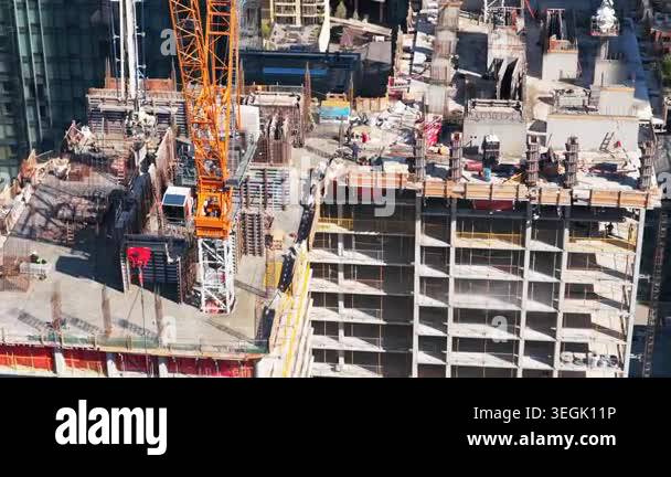 High rise building construction with tower crane and workers in ...