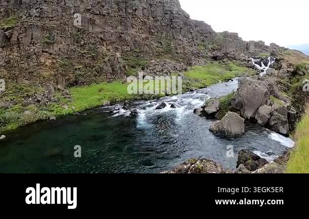 Cinematic shot of xar river flowing through Almannagj tectonic fault in ...