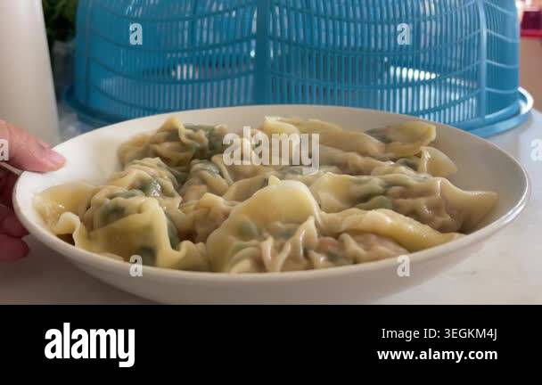 Close up of a hand rotating a white plate filled with steaming hot ...